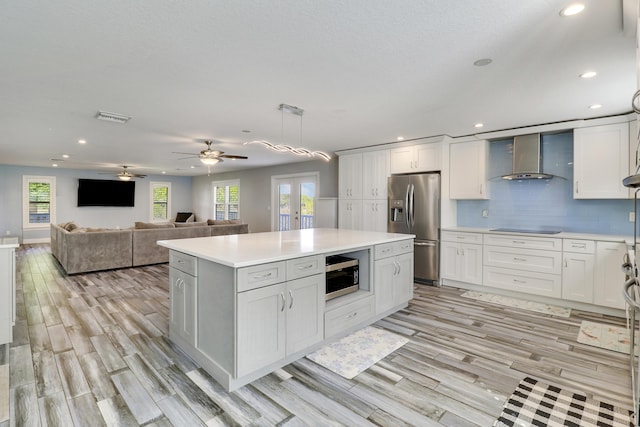 kitchen with french doors, light countertops, visible vents, appliances with stainless steel finishes, and wall chimney exhaust hood