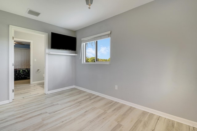 unfurnished bedroom featuring visible vents, light wood-style flooring, and baseboards