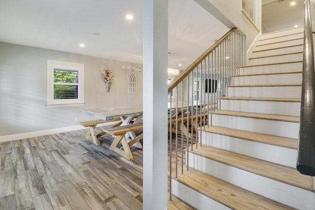 stairway featuring recessed lighting, wood finished floors, and baseboards