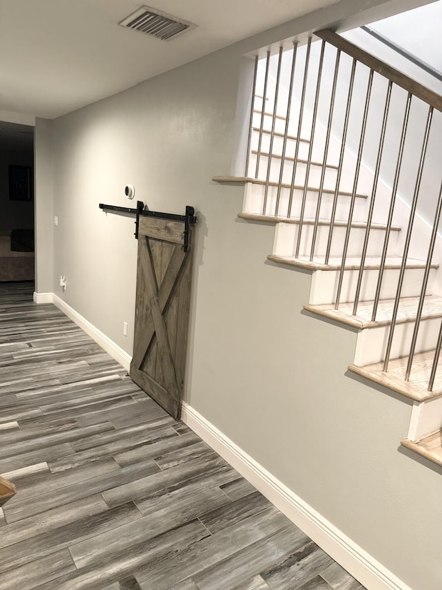 corridor with wood finished floors, visible vents, and baseboards