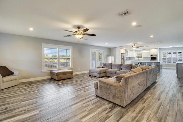 living area with recessed lighting, visible vents, baseboards, french doors, and light wood finished floors