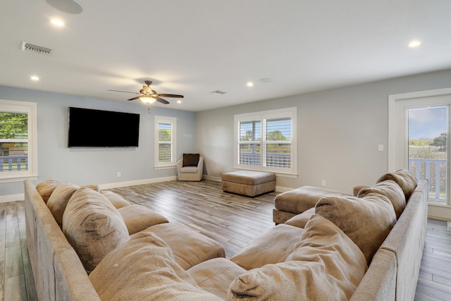 living area featuring hardwood / wood-style flooring, recessed lighting, visible vents, and baseboards