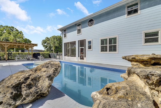 view of swimming pool with a patio area, fence, a sunroom, and a fenced in pool