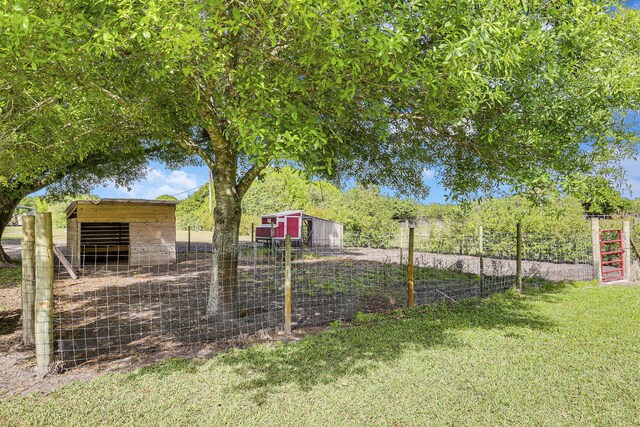 view of yard with fence and an outdoor structure