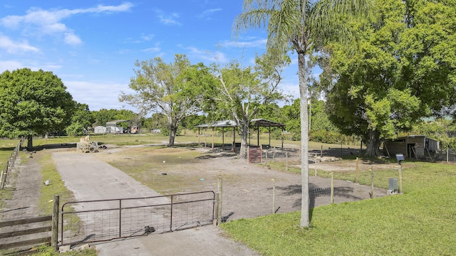 view of home's community featuring a lawn, fence, and a gate