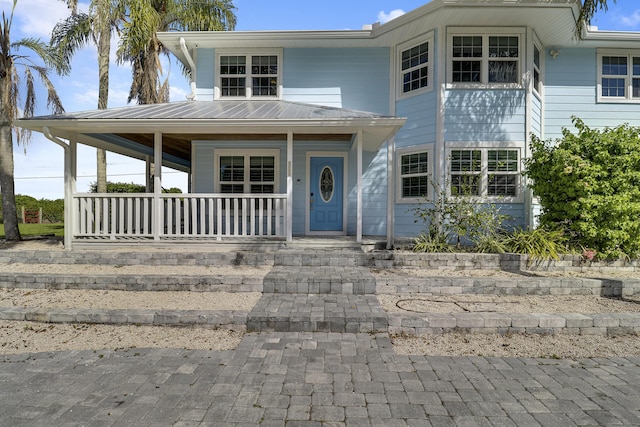 view of front of house featuring metal roof and a porch