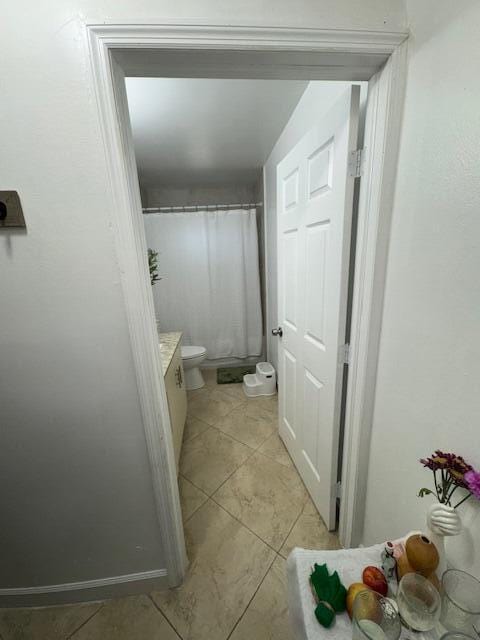 full bath with toilet, tile patterned flooring, and vanity