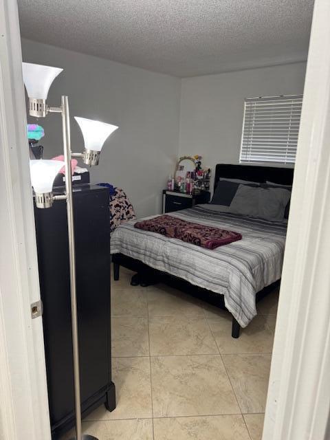 bedroom with a textured ceiling and light tile patterned flooring