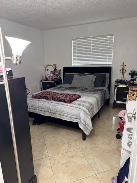 bedroom with a textured ceiling and light tile patterned floors