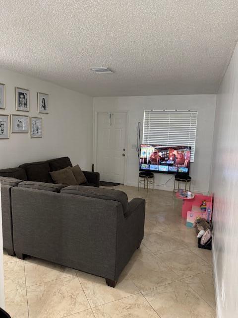 living room featuring a textured ceiling and visible vents