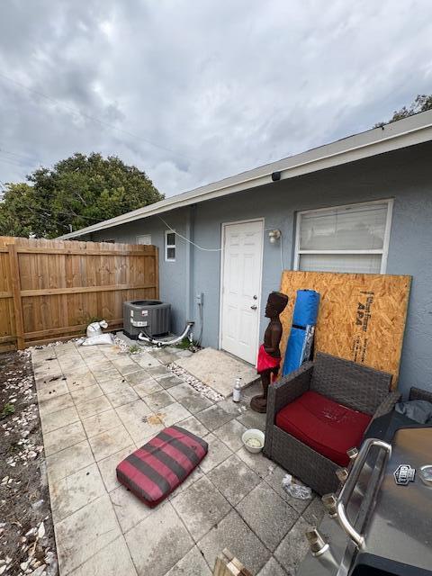 view of patio / terrace with central AC and fence