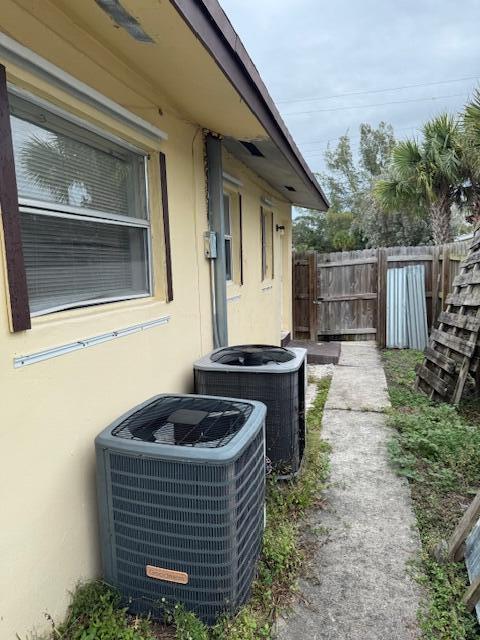 details with central AC, fence, and stucco siding