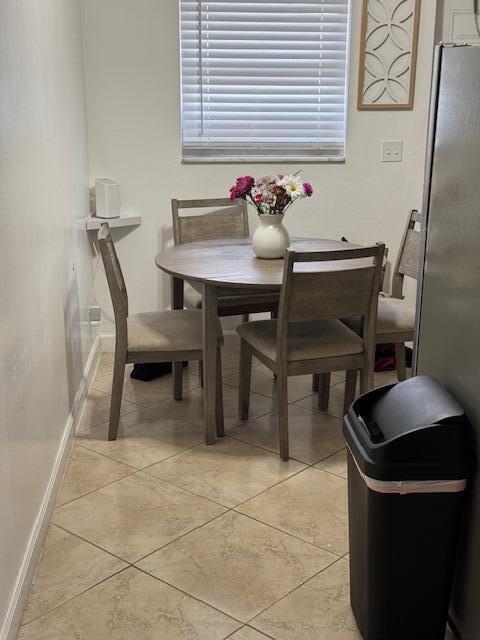 dining space featuring baseboards and light tile patterned floors