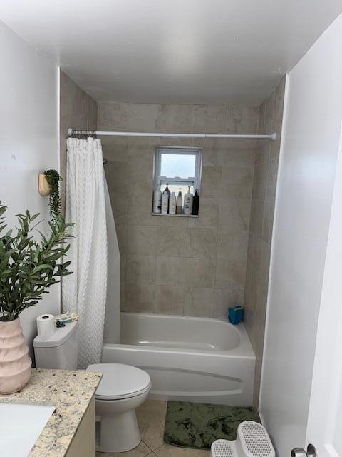 bathroom with toilet, tile patterned flooring, shower / tub combo with curtain, and vanity