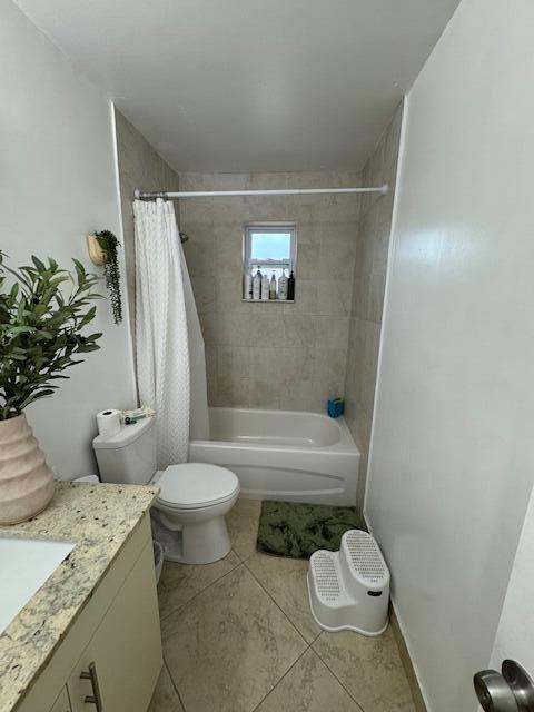 full bathroom featuring shower / bath combo, vanity, toilet, and tile patterned floors