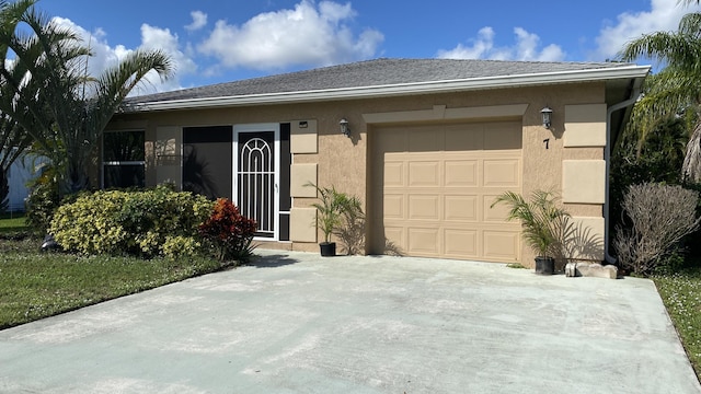 ranch-style home with a garage, driveway, and stucco siding