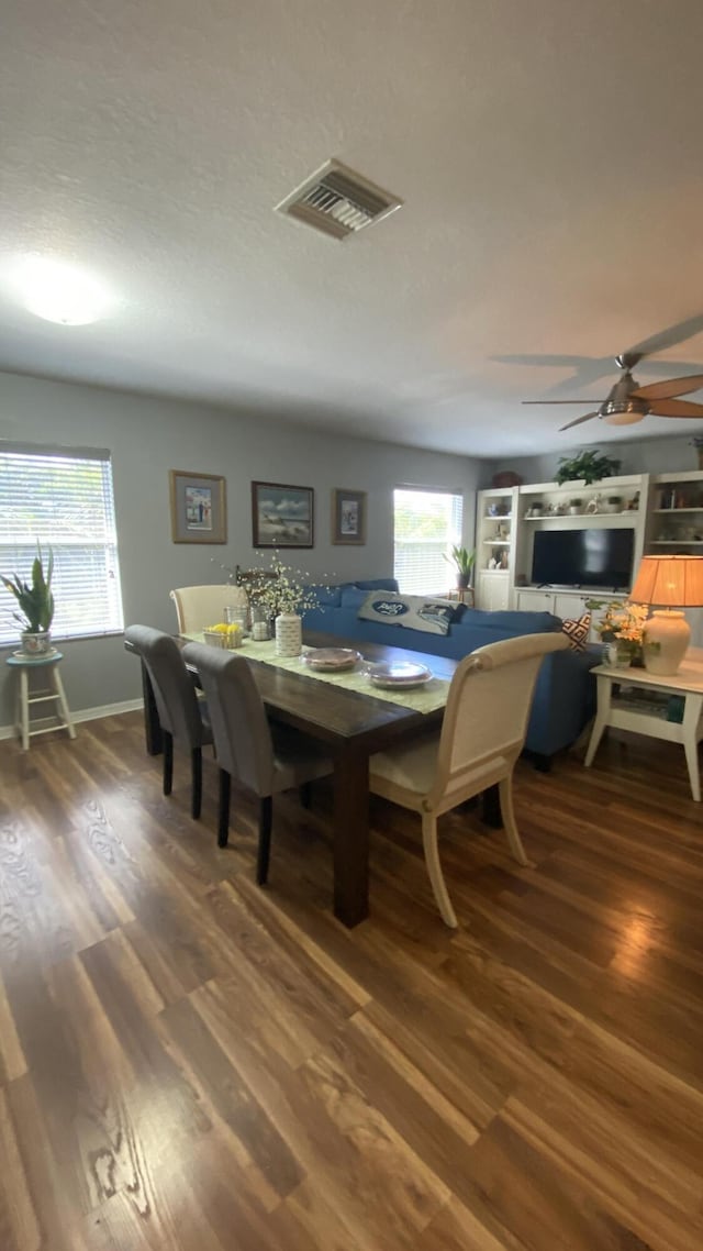 dining room with visible vents, ceiling fan, baseboards, and wood finished floors