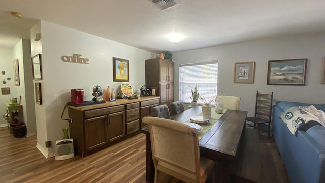 dining space with visible vents, dark wood finished floors, and baseboards