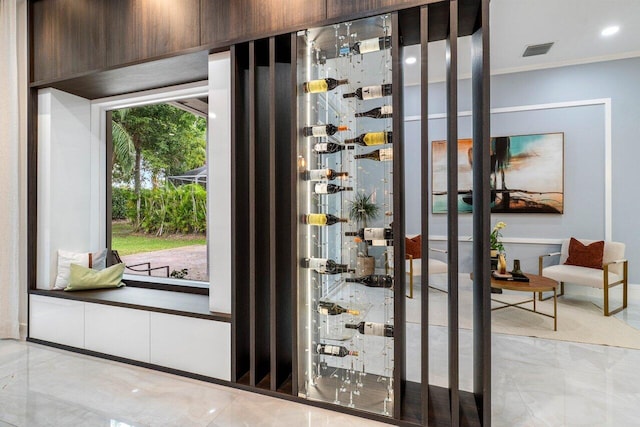 wine cellar featuring marble finish floor, visible vents, and crown molding