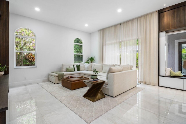 living area with baseboards, marble finish floor, and recessed lighting