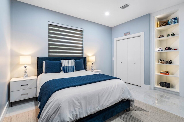 bedroom featuring a closet, marble finish floor, visible vents, and baseboards