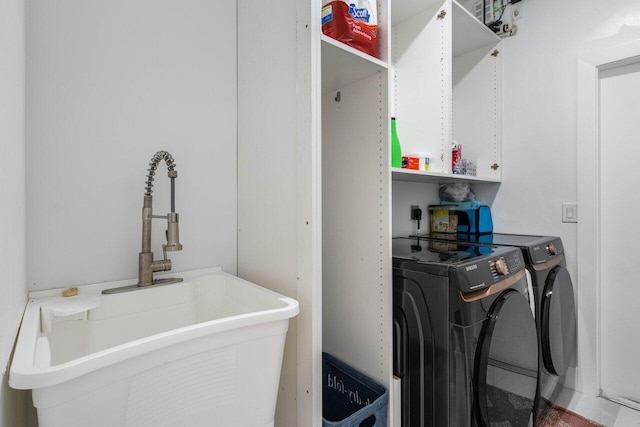 clothes washing area featuring independent washer and dryer and a sink