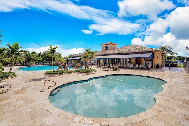 community pool featuring a patio area and fence