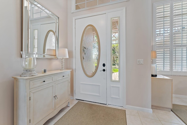 foyer featuring baseboards and light tile patterned floors