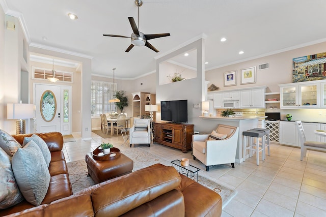 living room featuring light tile patterned floors, ceiling fan, ornamental molding, and visible vents