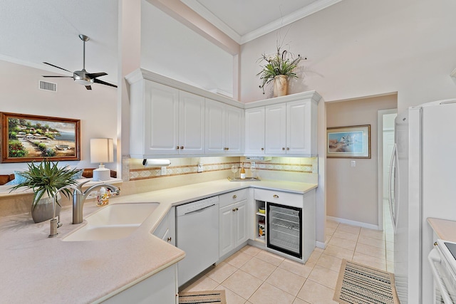 kitchen featuring white appliances, ornamental molding, light countertops, and a sink