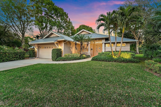 7565 SE Teton Dr, Hobe Sound, FL 33455 - ranch-style house featuring driveway, a front yard, metal roof, and a garage