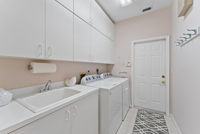 laundry area featuring cabinet space, light tile patterned floors, visible vents, separate washer and dryer, and a sink