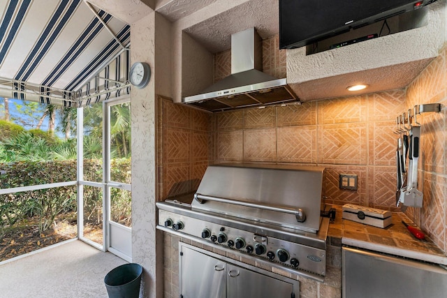 kitchen with tile countertops and wall chimney exhaust hood