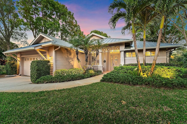 7565 SE Teton Dr, Hobe Sound, FL 33455 - single story home featuring a standing seam roof, driveway, metal roof, a garage, and a front yard
