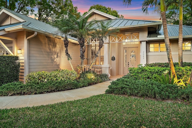 7565 SE Teton Dr, Hobe Sound, FL 33455 - property entrance with stucco siding, a standing seam roof, and metal roof