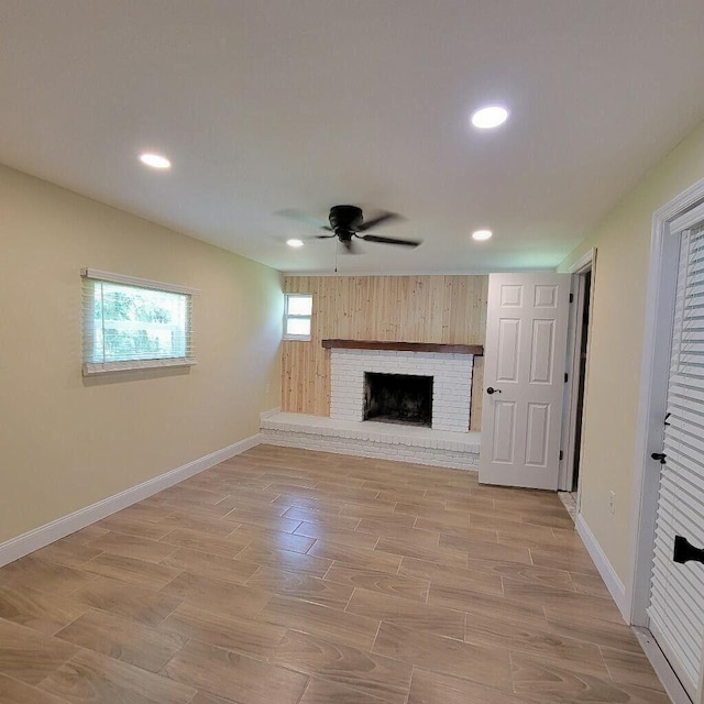 unfurnished living room featuring recessed lighting, a fireplace, a ceiling fan, baseboards, and light wood-type flooring