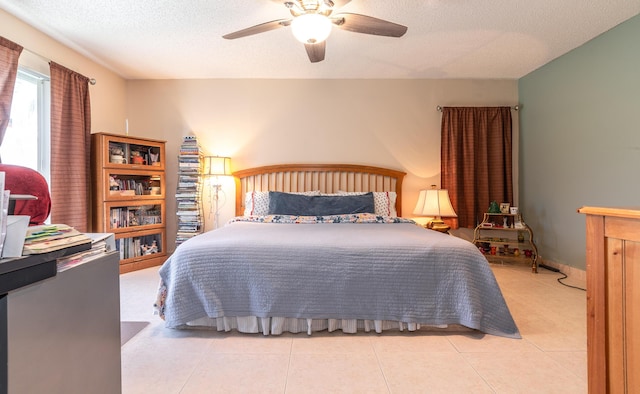 bedroom featuring light tile patterned flooring, ceiling fan, and a textured ceiling