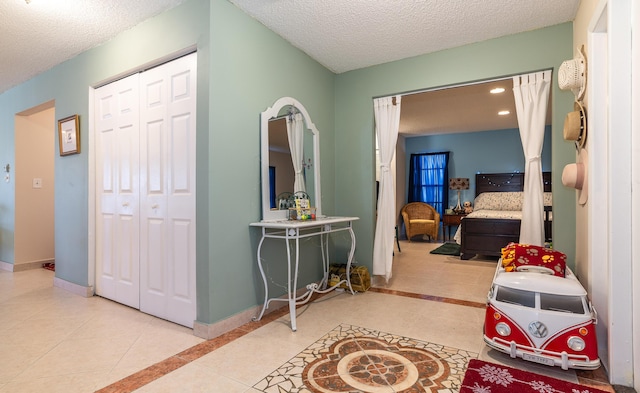 interior space featuring tile patterned flooring, a textured ceiling, baseboards, and recessed lighting