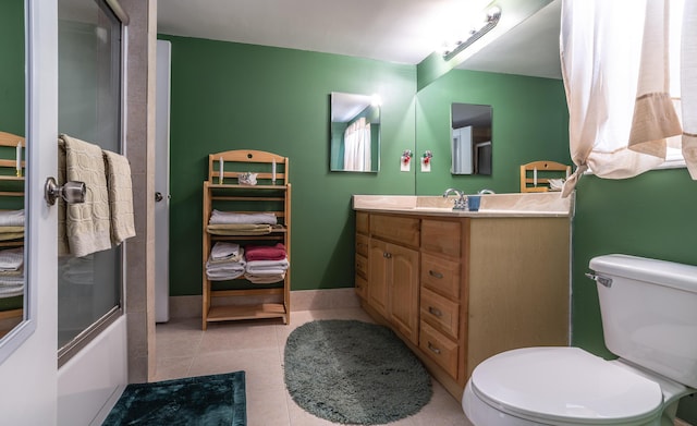 full bathroom featuring baseboards, bath / shower combo with glass door, toilet, tile patterned flooring, and vanity