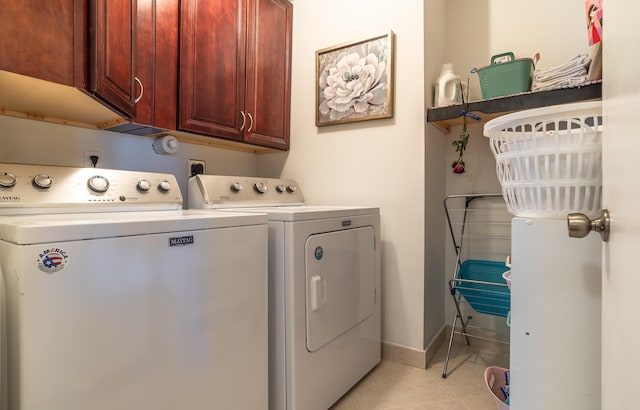 washroom featuring light tile patterned floors, washing machine and clothes dryer, cabinet space, and baseboards