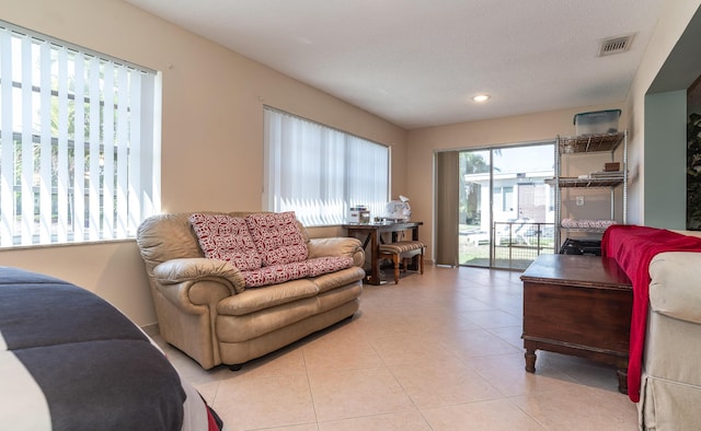 living area with light tile patterned floors, visible vents, and recessed lighting