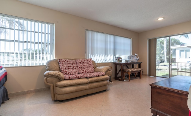 tiled living area featuring recessed lighting, a textured ceiling, and baseboards