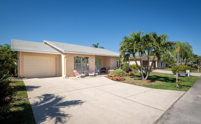 ranch-style house featuring a front lawn, driveway, an attached garage, and stucco siding