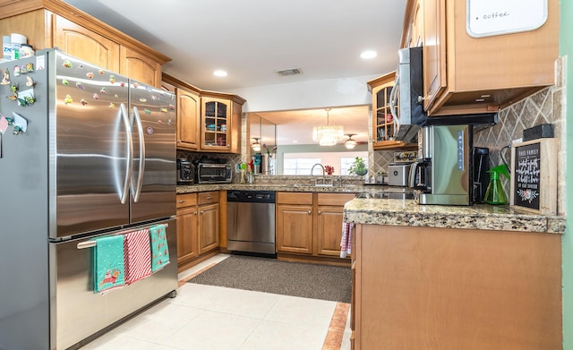 kitchen with visible vents, decorative backsplash, appliances with stainless steel finishes, glass insert cabinets, and a sink