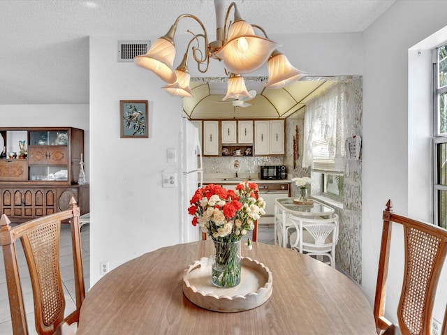 dining room featuring visible vents and a textured ceiling