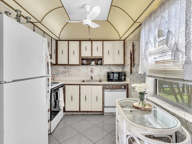 kitchen featuring light tile patterned floors, ceiling fan, white appliances, a sink, and light countertops