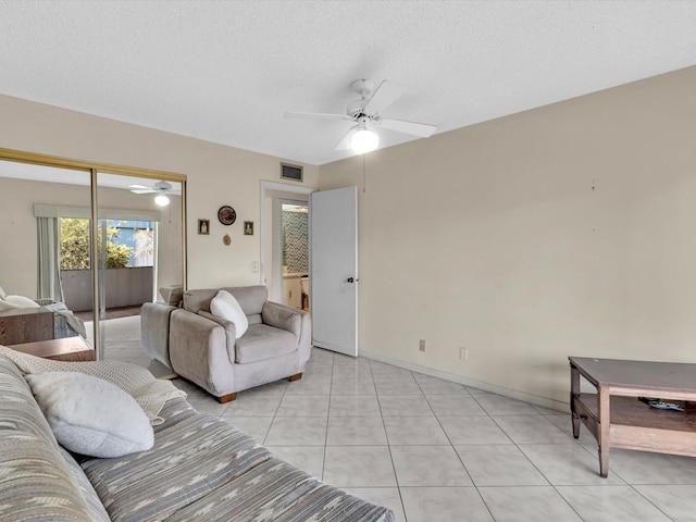 living room with light tile patterned floors, ceiling fan, a textured ceiling, visible vents, and baseboards