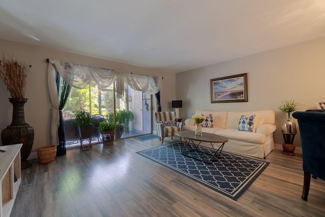 living area with baseboards and wood finished floors