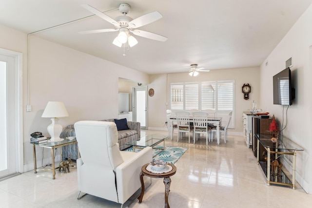 living room featuring light tile patterned flooring, a ceiling fan, and baseboards