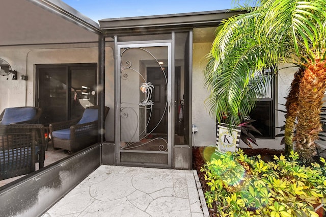 doorway to property featuring stucco siding